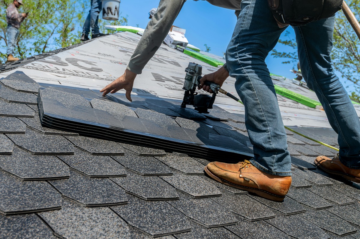 man shingling a roof